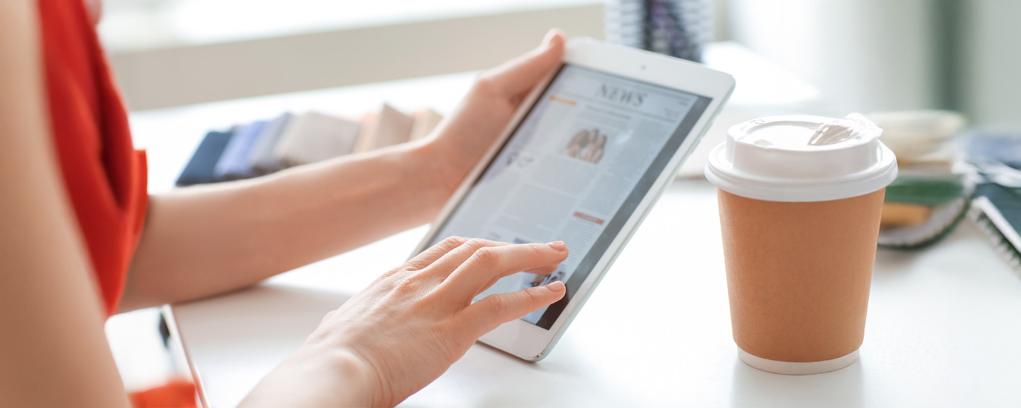 Young woman reading news on tablet computer screen at home
